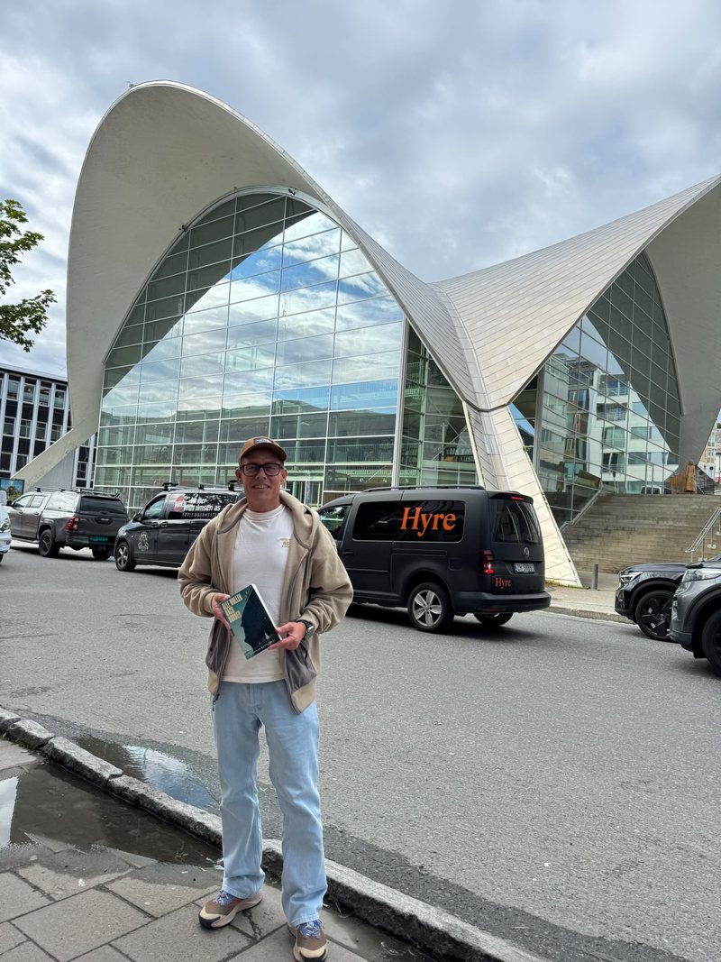 Stephan Buttgereit mit dem Roman Alle wollen nach Norden vor dem geschwungenen Dach der Stadtbibliothek von Tromsø